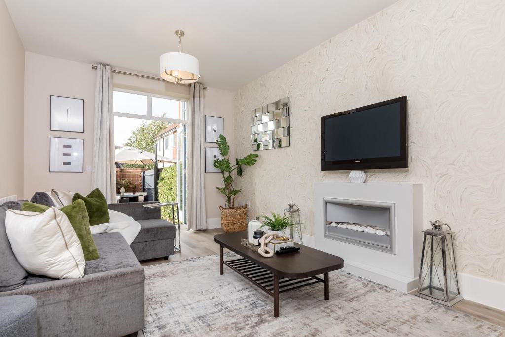 a living room with a couch and a fireplace at Heliodoor Apartments Milton Keynes Spacious 5 Bedroom House with Free Parking, Near M1 J14 in Broughton