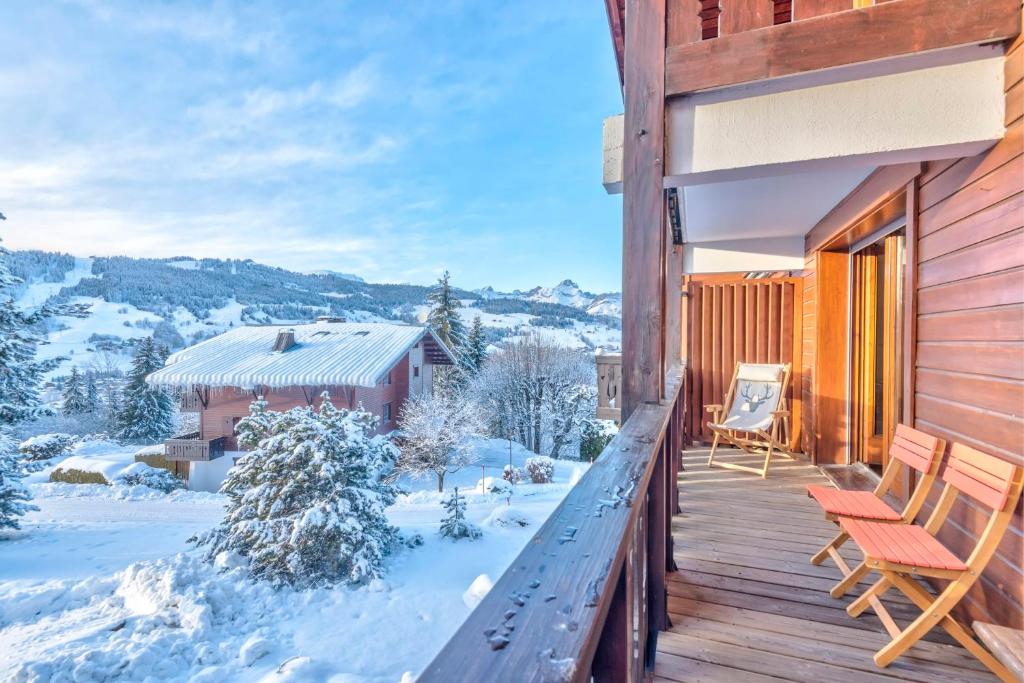 a wooden deck with two chairs on it in the snow at Wonderful appartement in a chalet with balcony - Megève - Welkeys in Megève
