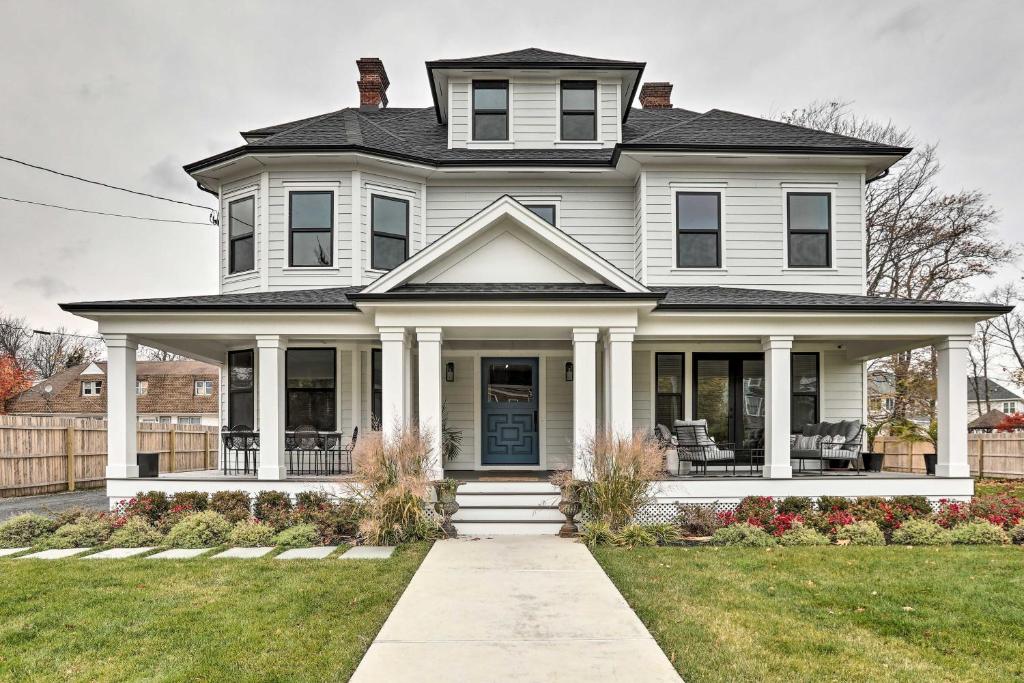 una casa bianca con portico e prato di Grand Long Branch Home 1 Block to Beach! a Long Branch