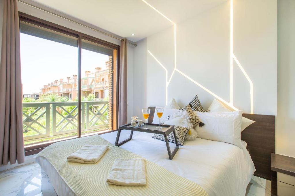 een slaapkamer met een bed en een groot raam bij Luxe et Cosy - 3 Chambres - Fitness - Wifi in Marrakesh