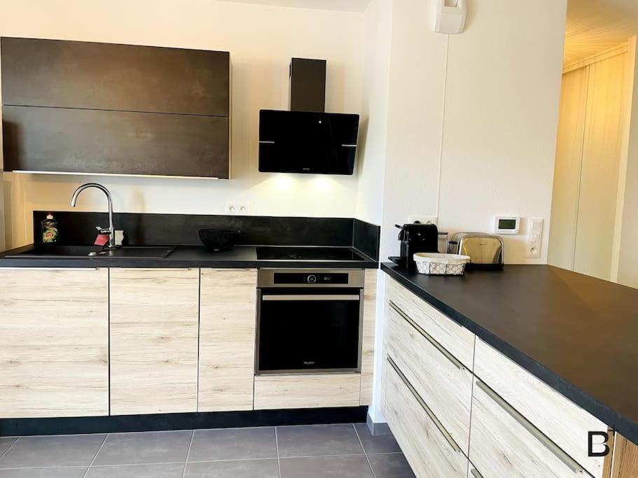 a kitchen with a sink and a stove top oven at L'Esplanade in Besançon