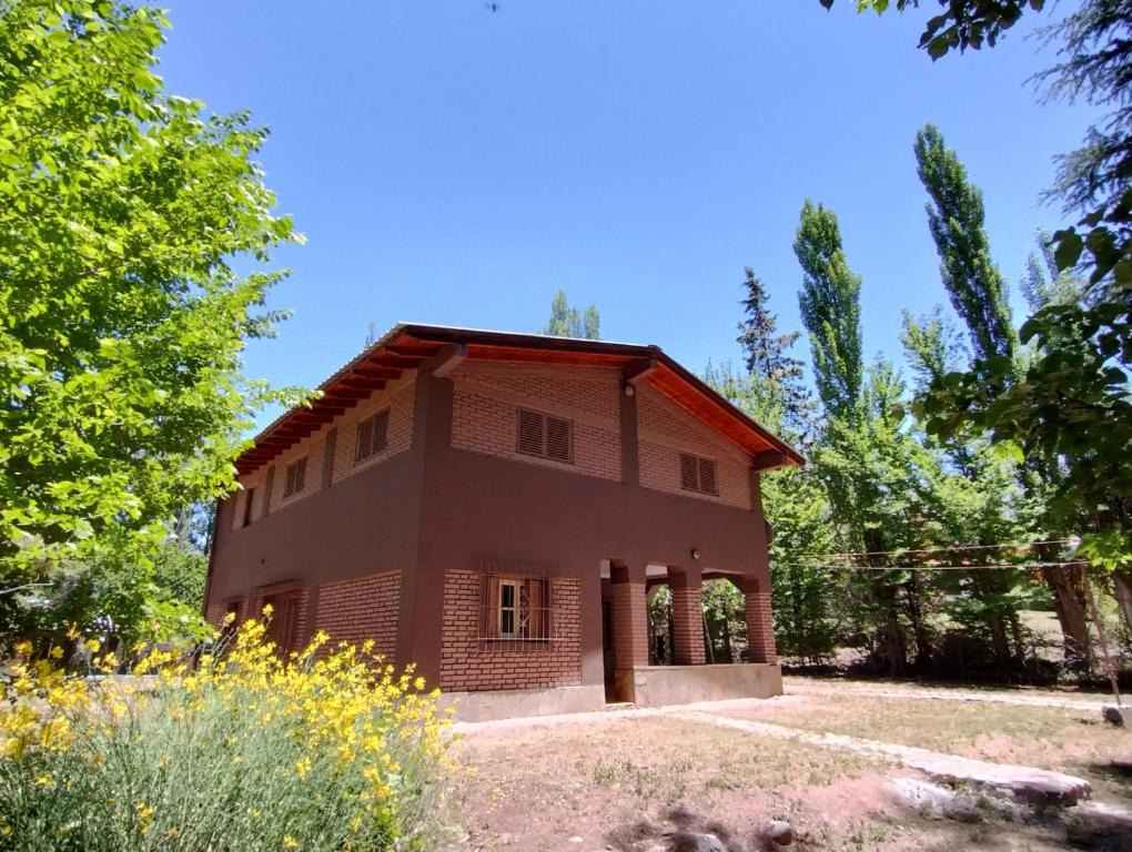 ein Haus inmitten eines Feldes mit Bäumen in der Unterkunft Casa Gloria y Vicente in Potrerillos
