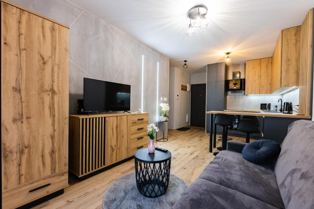 a living room with a couch and a kitchen at Hello Kielce in Kielce