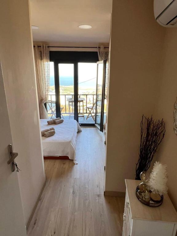 a room with two beds and a balcony with the ocean at Fira center houses in Fira