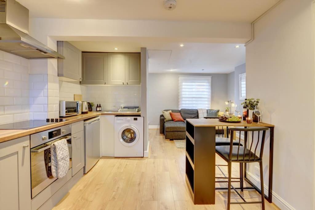 a kitchen and living room with a table and a stove at One Bedroom Apartment in Banbury Town Centre 5 Min Walk to Train Station with Fast Wifi and Smart Tv in Banbury
