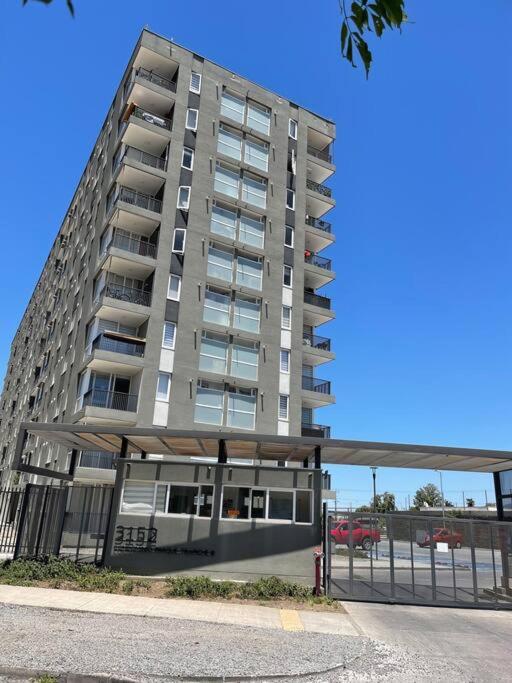 a tall apartment building with a fence in front of it at Hermoso Depto Piscina in Rancagua