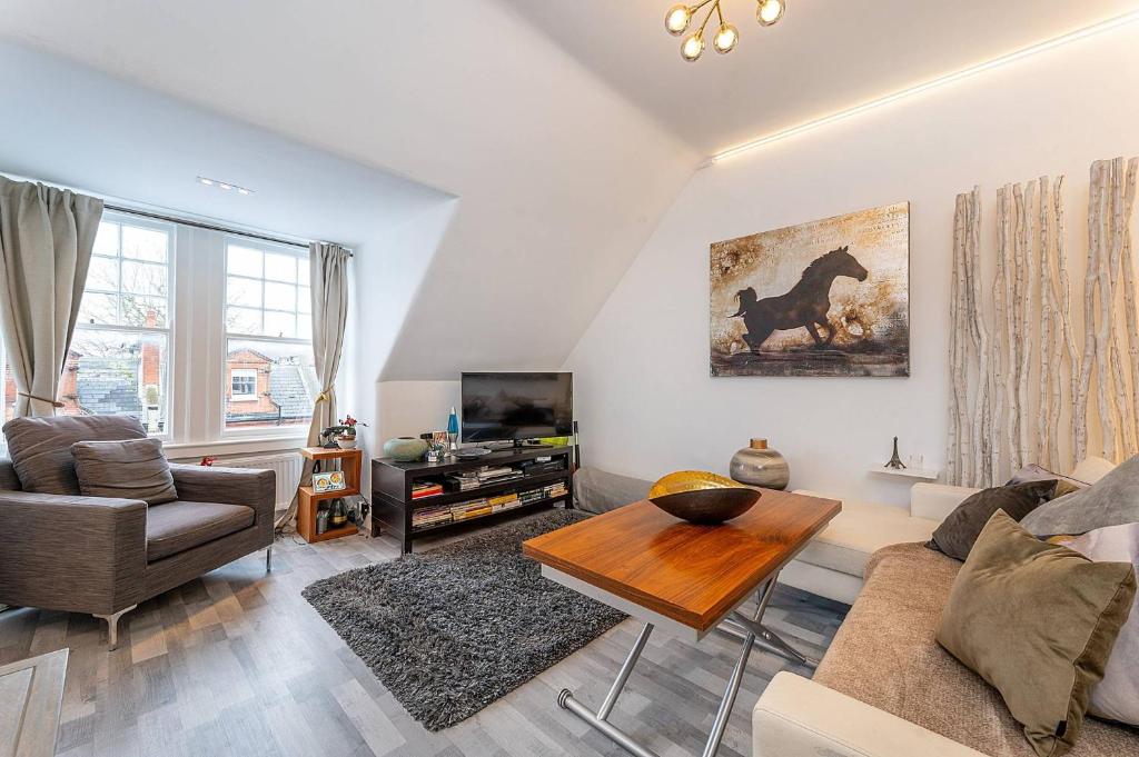 a living room with a couch and a table at Stylish, modern, Kensington apartment in London