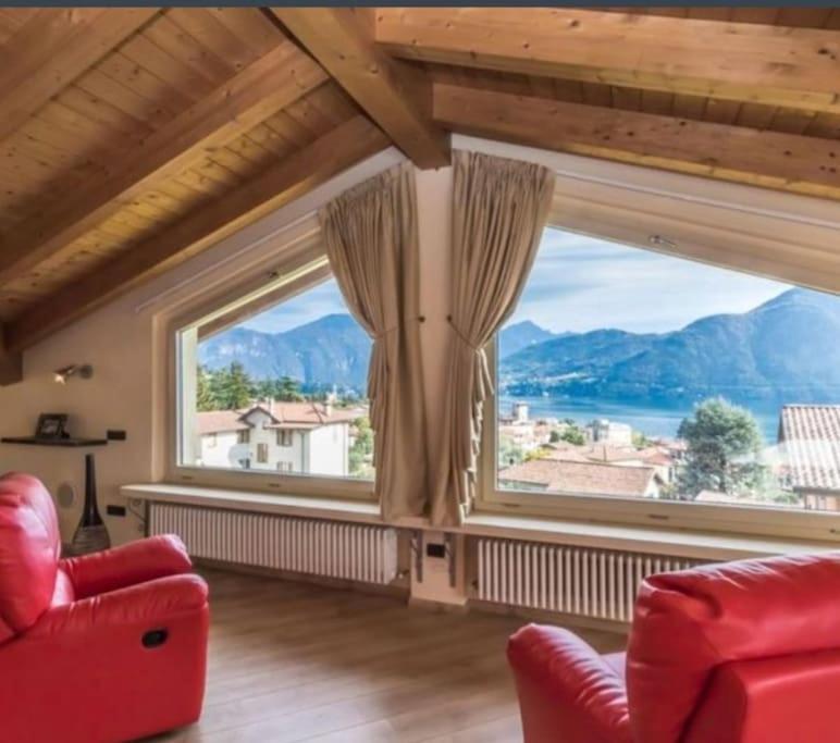 a living room with a red couch and a large window at Villa (Le Calle) Brezza del Lago - Tremezzina. in Mezzegra
