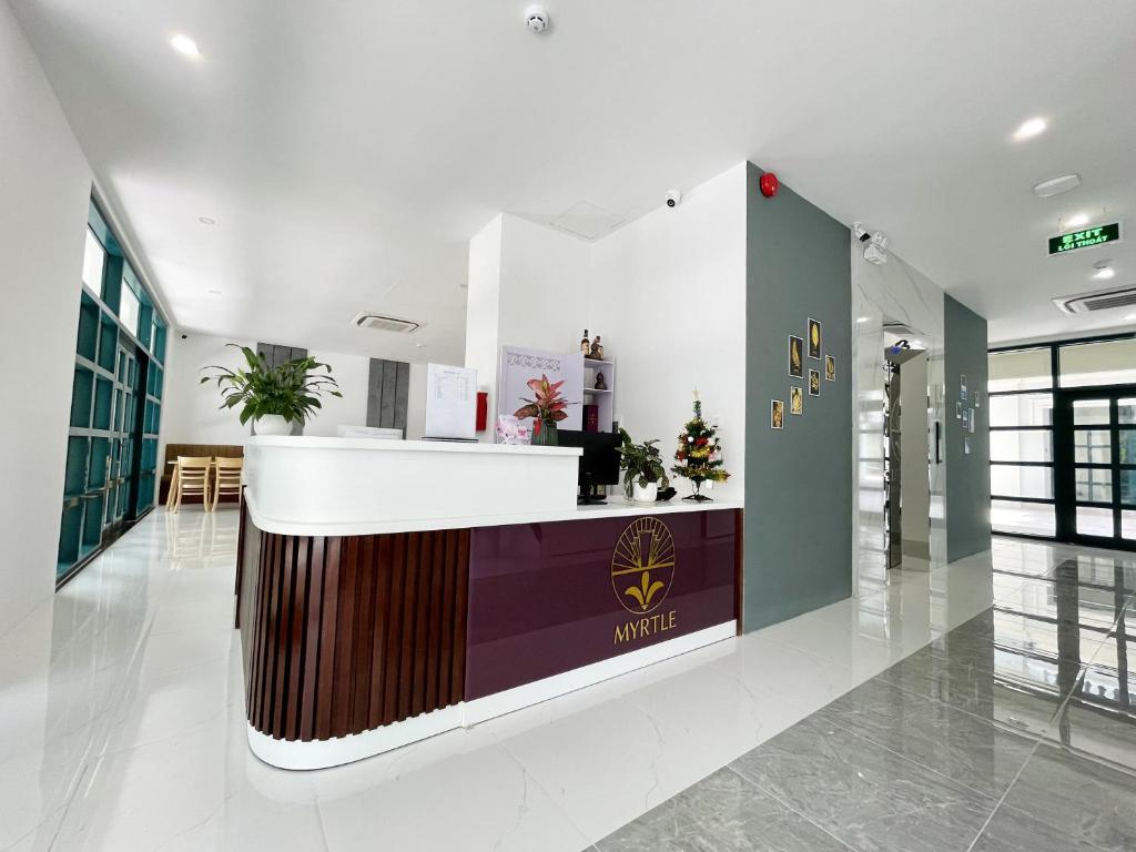 a lobby with a counter in the middle of a building at Myrtle Boutique Hotel Phu Quoc in Phu Quoc