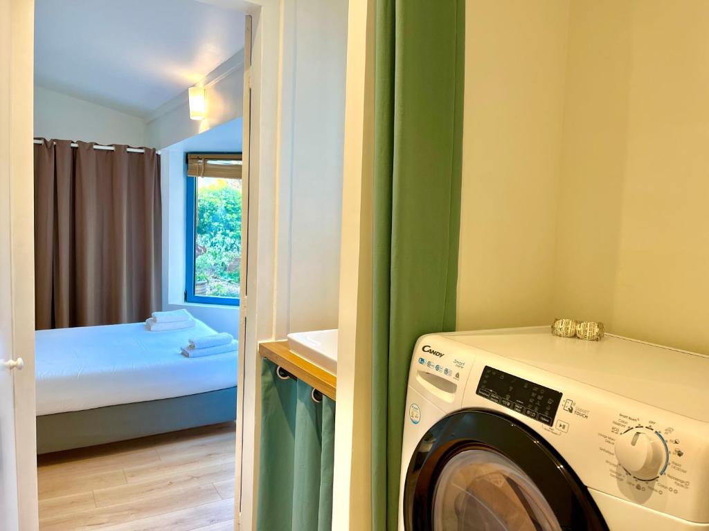 a laundry room with a washing machine and a bedroom at Le Jardin Des Sacres - HyperCentre Cathédrale in Reims