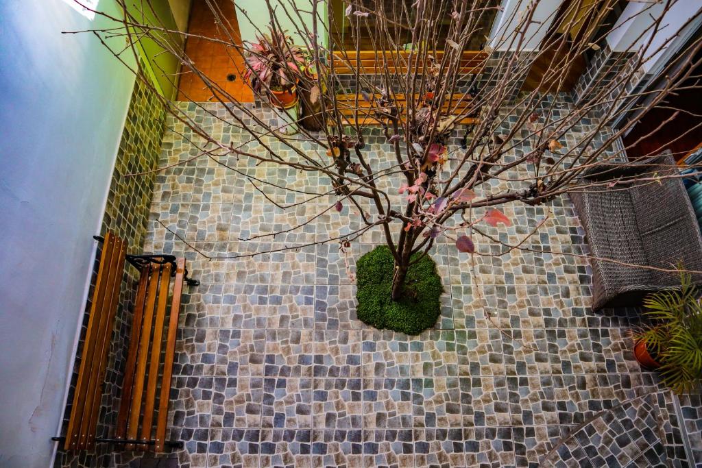 Una pared de mosaico con un árbol. en Inka City Hostel, en Cusco