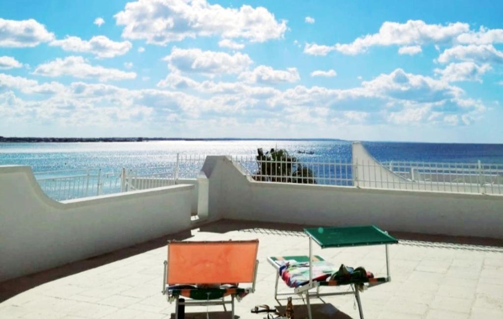 balcone con 2 sedie e vista sull'oceano. di Anna House Vista Mare a Torre Lapillo