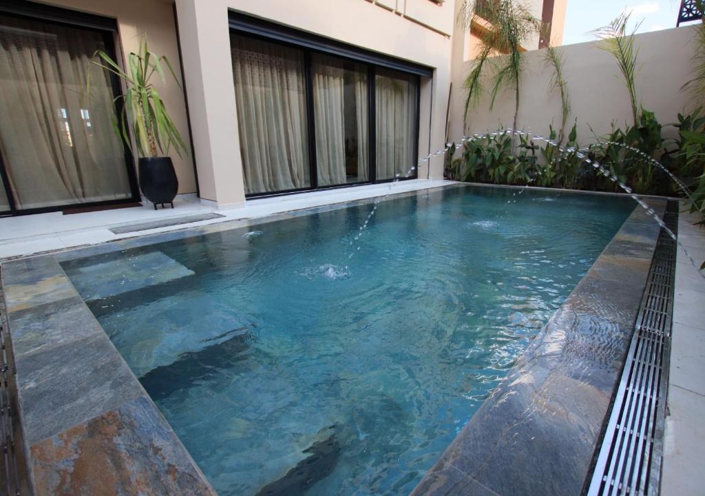 a swimming pool in the middle of a house at Vista de La Palma villa in Marrakesh