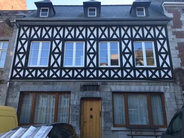 een zwart-wit gebouw met ramen en een deur bij Les colombages in Dinant