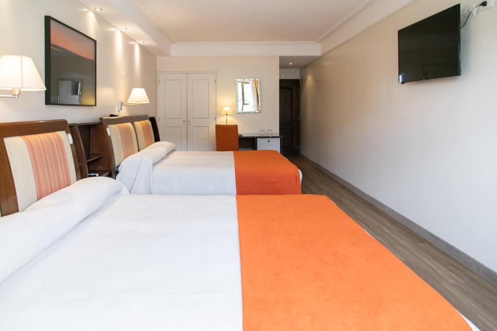 um quarto de hotel com duas camas e uma televisão de ecrã plano em Hotel Almería em Salta