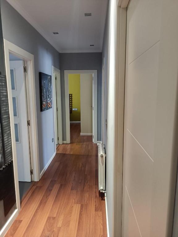 a hallway of an apartment with wooden floors and white walls at Habitación privada en casa particular in Albacete