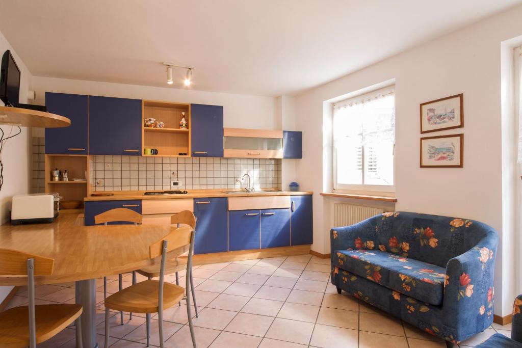 una cucina con armadi blu, tavolo e divano di Ciasa Buro - Coba a Moena