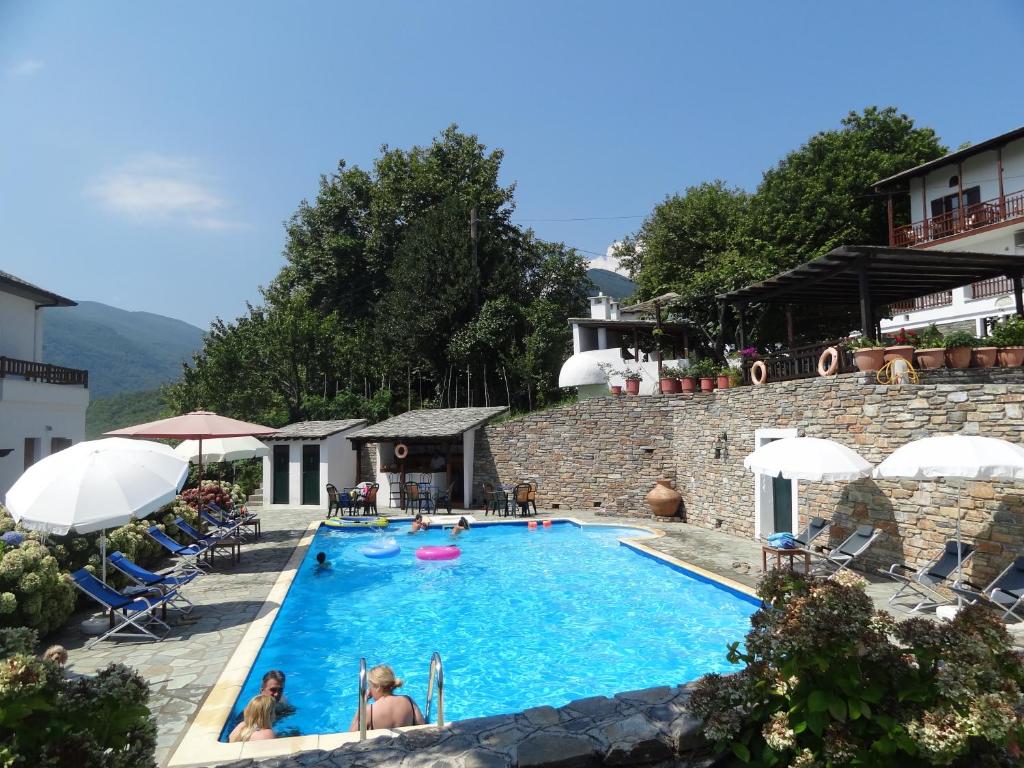 a pool at a hotel with people in it at Hotel Vrionis in Agios Dimitrios