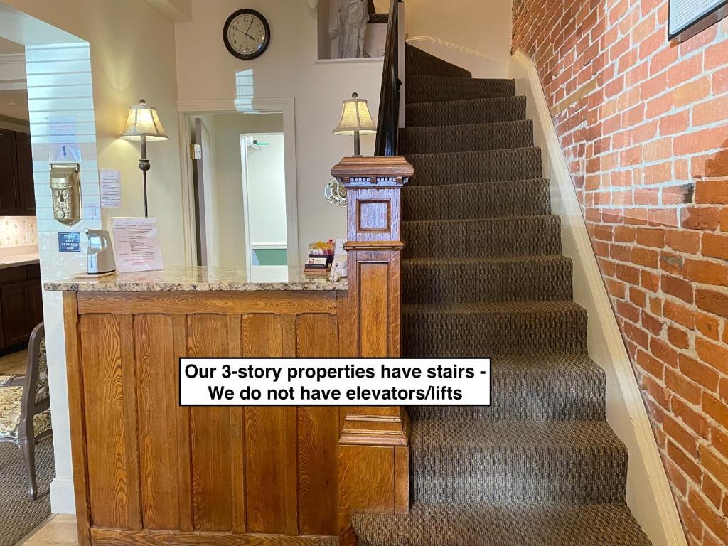 a staircase with a sign that says our story properties have stairs we do not at Oasis Guest House in Boston