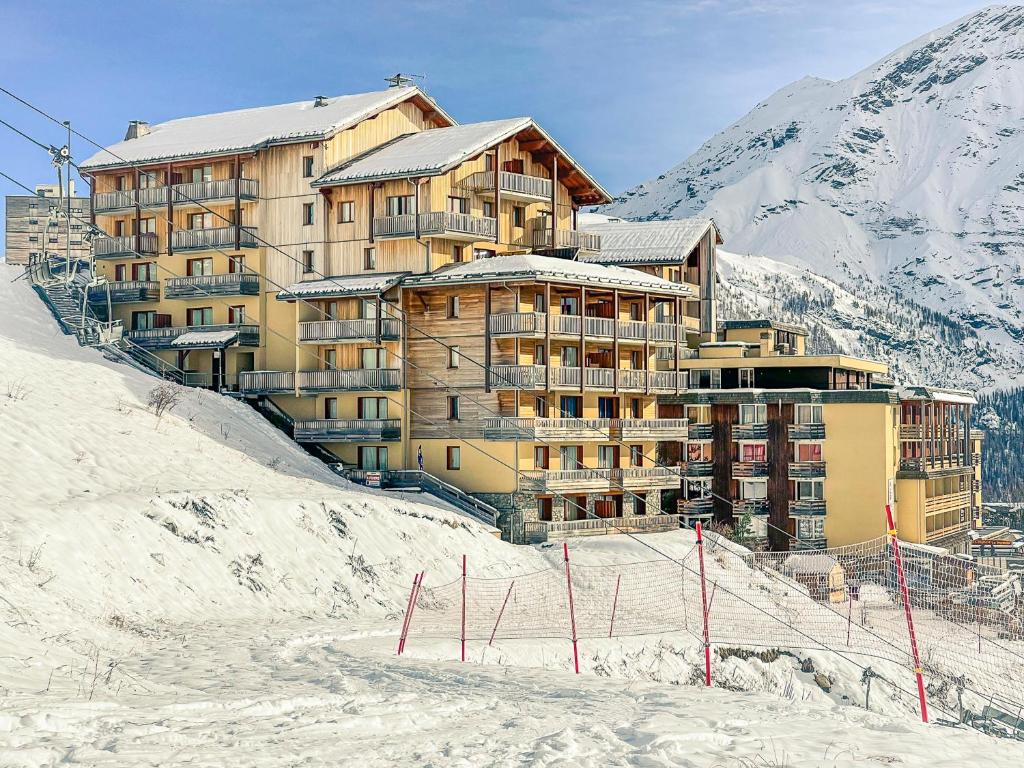 un grand bâtiment au sommet d'une montagne enneigée dans l'établissement Résidence les Terrasses De La Bergerie (by Sabine et JeanKry), à Orcières