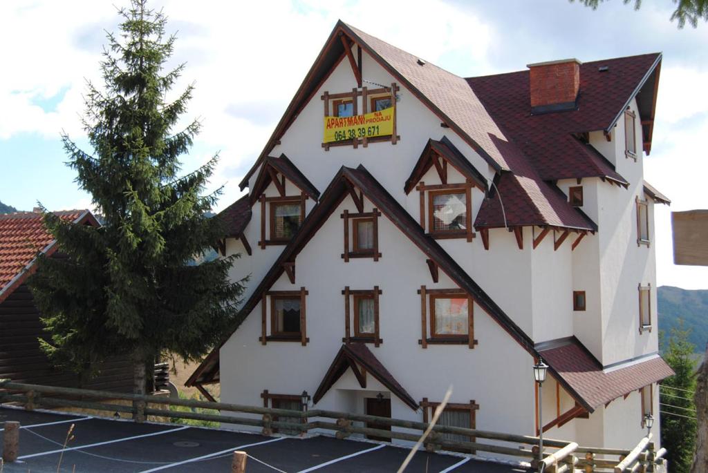 un grand bâtiment blanc avec un toit marron dans l'établissement Villa Sofija, à Kopaonik