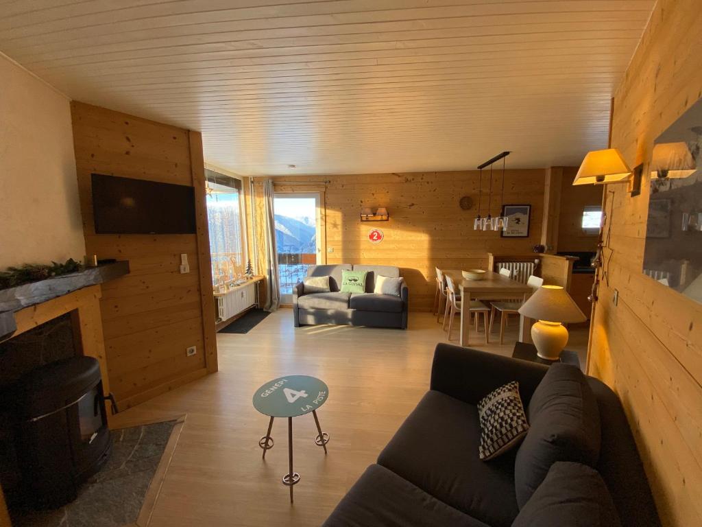 uma sala de estar com um sofá e uma mesa em Appartement cosy au pied des pistes em La Clusaz