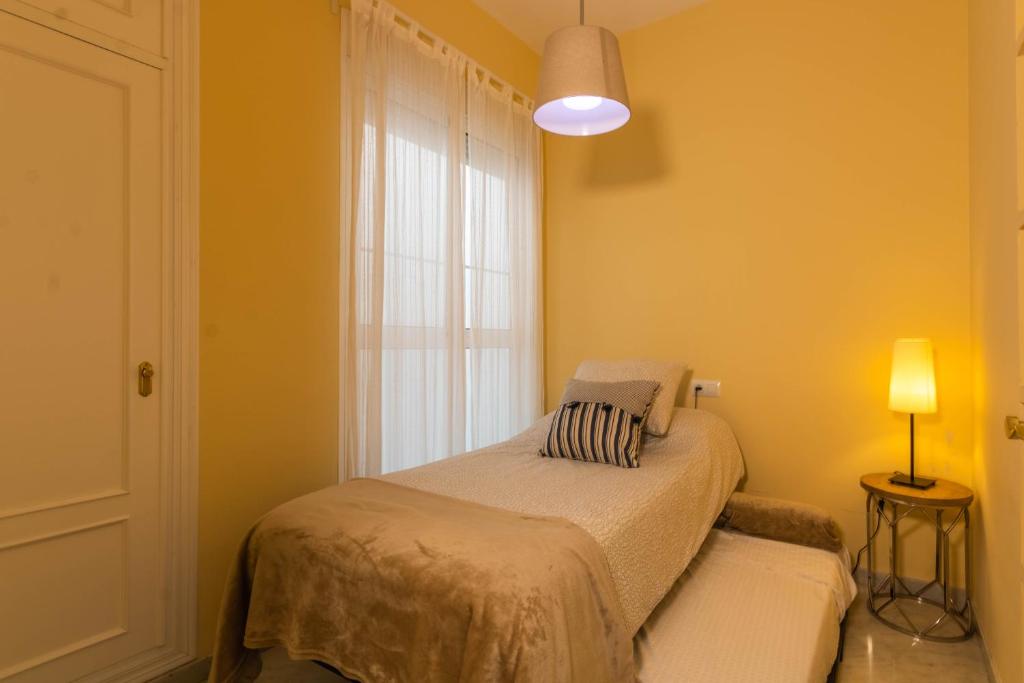A bed or beds in a room at Apartamento DUX VERAGUA Centro Sevilla