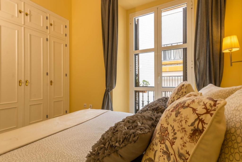 A bed or beds in a room at Apartamento DUX VERAGUA Centro Sevilla