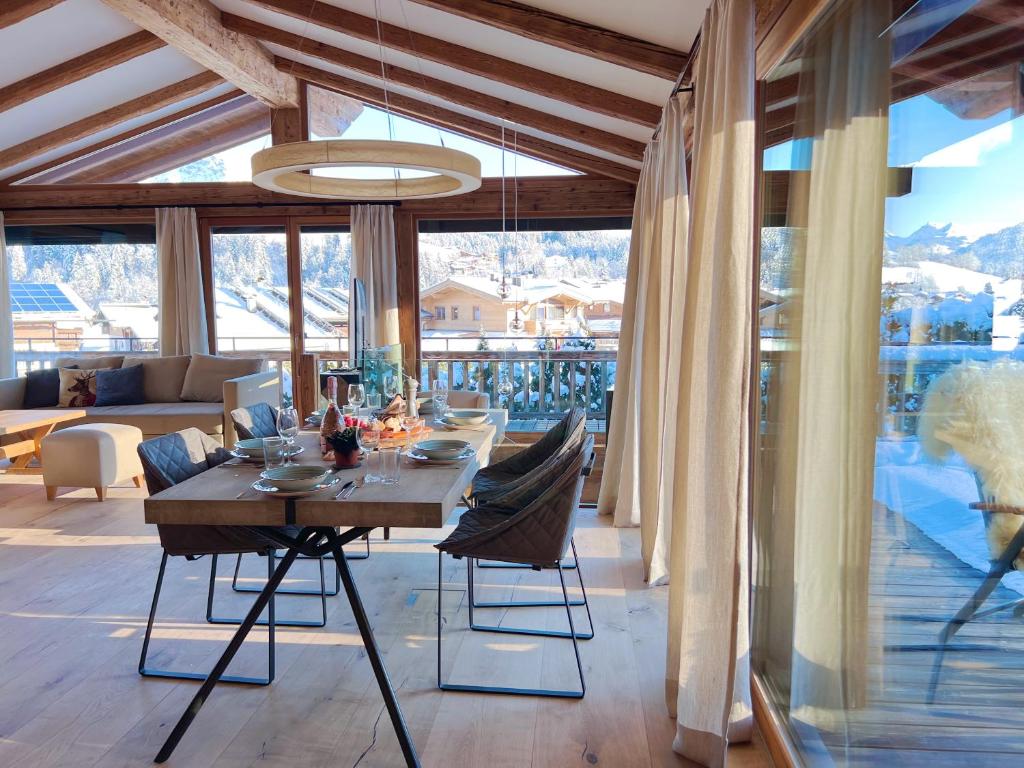une salle à manger avec une table et des chaises dans une maison dans l'établissement HIDEAWAY DESIGN CHALET by Belle Stay, à Kitzbühel