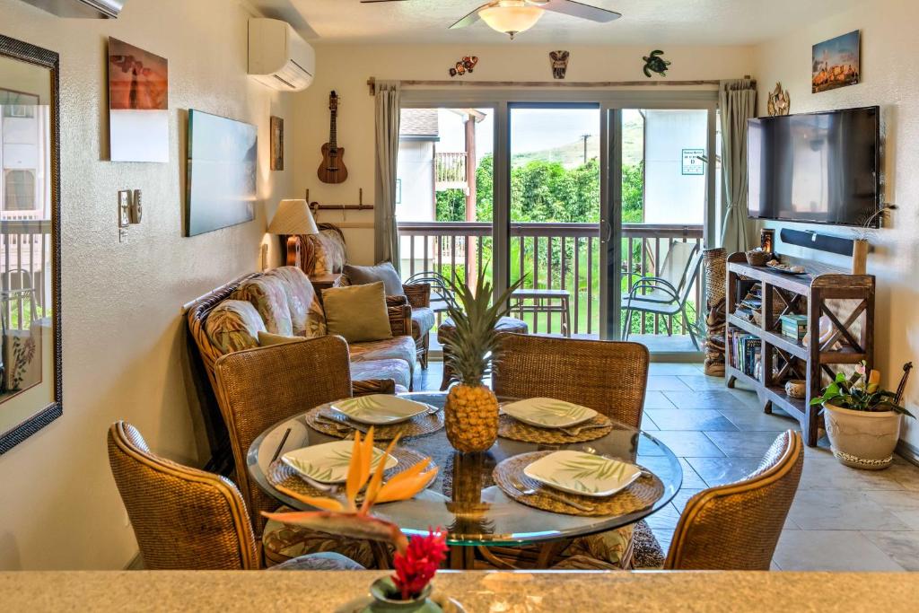 a living room with a table and chairs at Pristine Lihue Condo with Balcony Walk to Beach! in Lihue