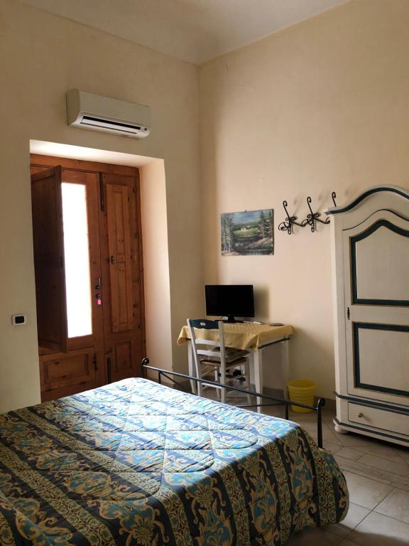 um quarto com uma cama e uma secretária em B&b Candido Vacanze em Modica