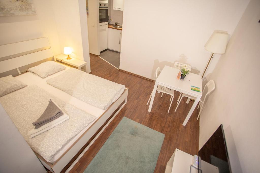 Habitación pequeña con cama y mesa pequeña. en Innsbruck City Center Studio I 24h self-check-in, en Innsbruck