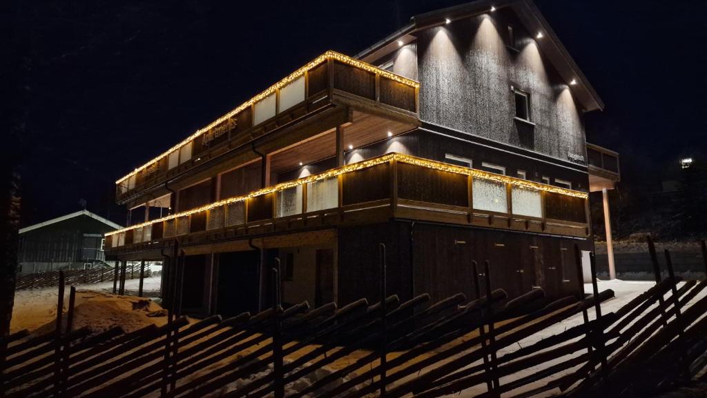 a wooden house with lights on the side of it at Haugetuft Apartments in Åmot