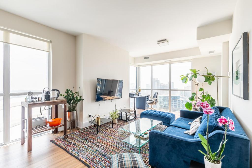 uma sala de estar com um sofá azul e uma televisão em Cloud 9 in Downtown Toronto em Toronto