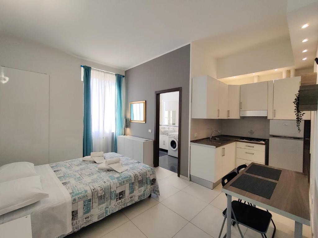 1 dormitorio con cama, mesa y cocina en B&B Intero Appartamento Forum e Metro Milanofiori, en Assago