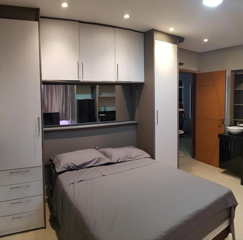 a bedroom with a bed and white cabinets at Studio Maraba-LOFT LINDO in Marabá