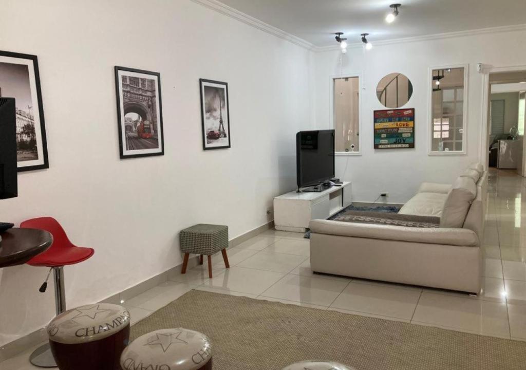 uma sala de estar com um sofá e uma televisão em WR7 Hostel em São Bernardo do Campo