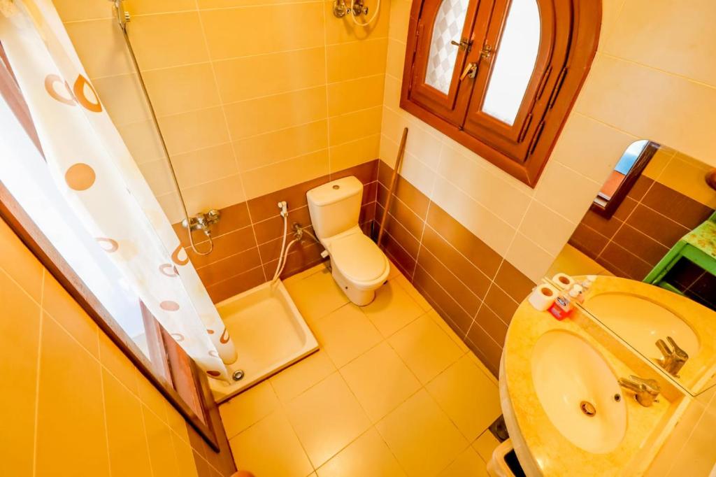 a bathroom with a sink and a toilet and a window at DownTown Hotel in Dahab