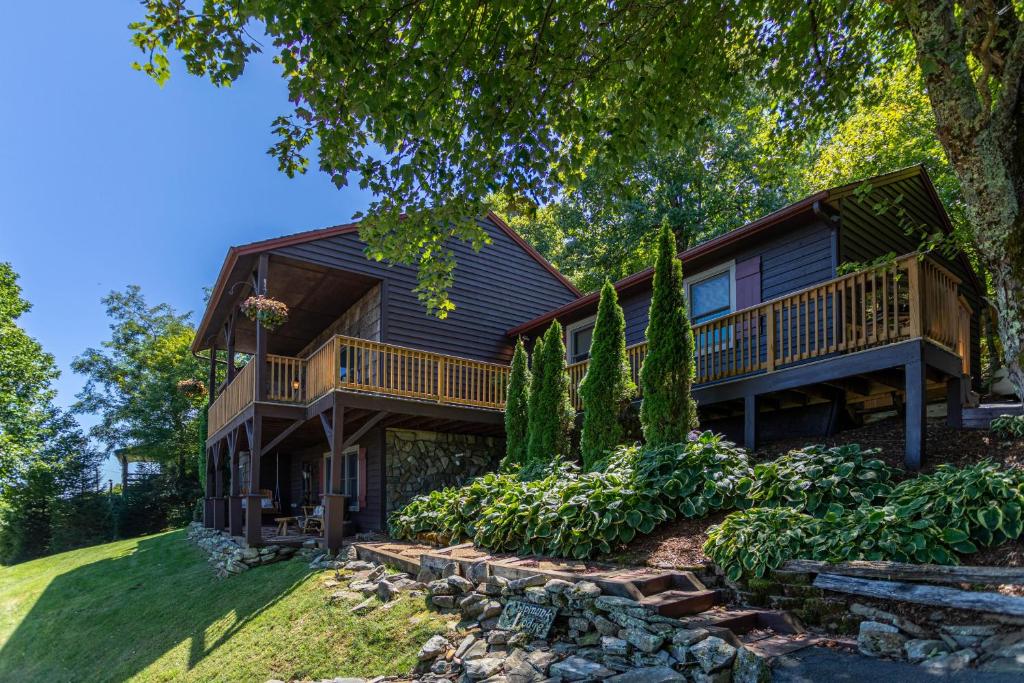 a log home with a deck and landscaping at Chipmunk View Lodge in Blowing Rock