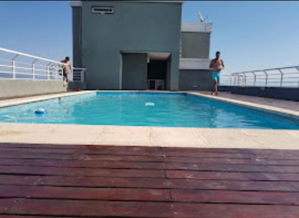 una piscina con 2 hombres junto a un edificio en Azucena Apart en Salta