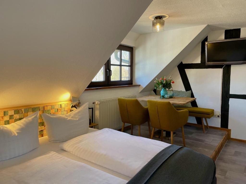 a bedroom with a bed and a table with chairs at Luisenhof in Neuglobsow