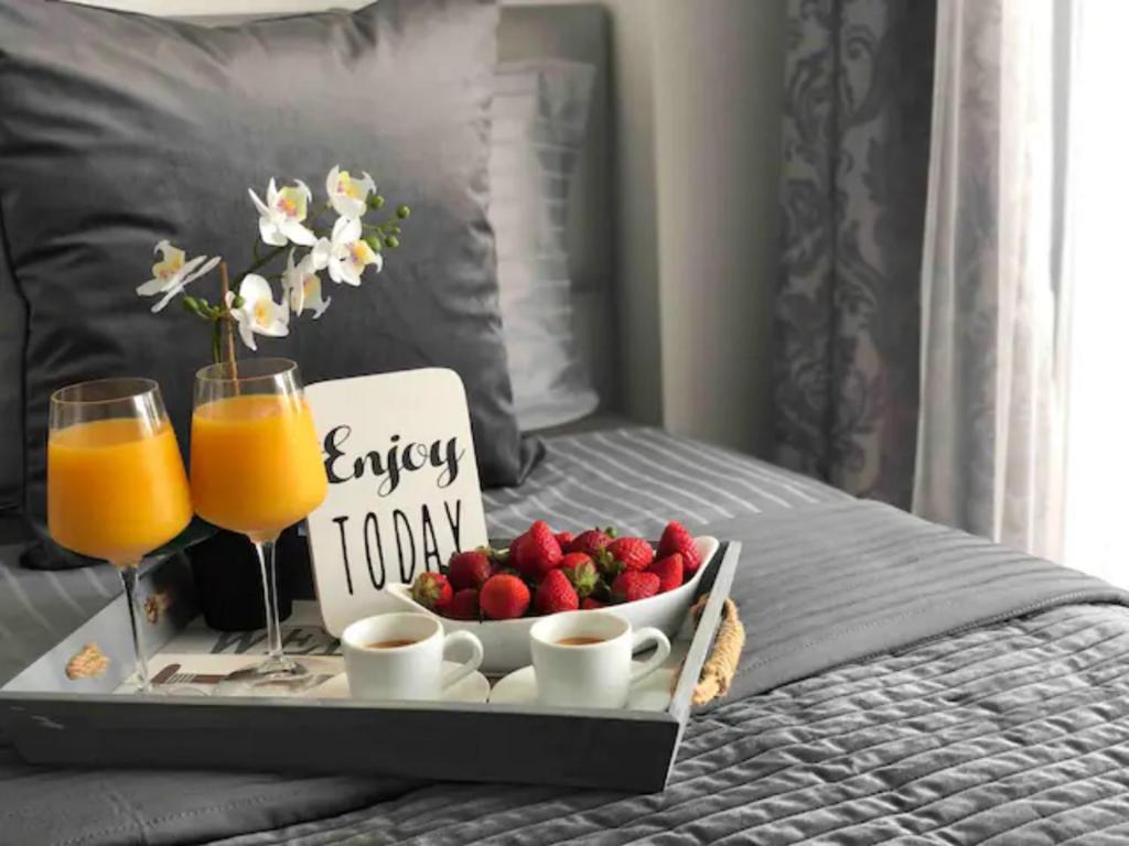 a tray of fruit and drinks on a bed at Wonderful apartment in the heart of Fuengirola and close to the beach in Fuengirola