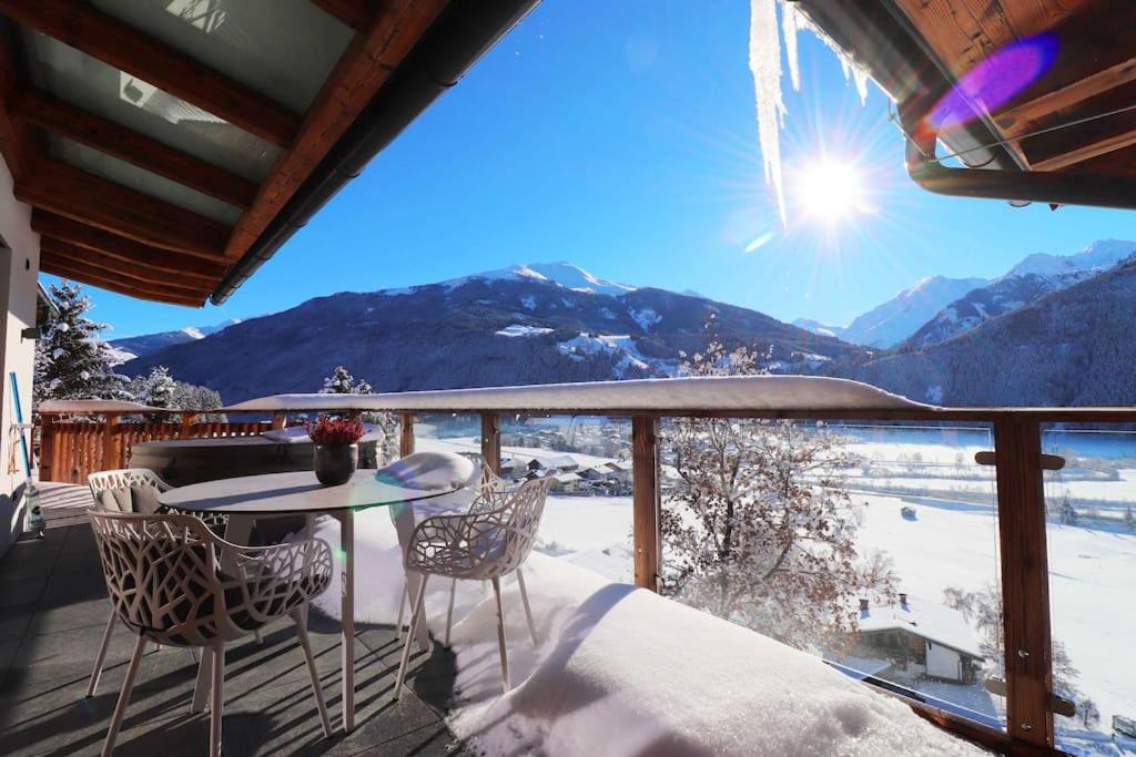 a table and chairs on a balcony with a view at Kitzbüheler Alpenpenthouse *private Sauna&Whirlpool* by STELLENBERG living in Hollersbach im Pinzgau