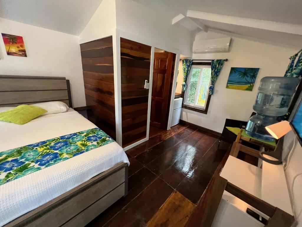 a bedroom with a bed and a wooden floor at Colinda Cabanas in Caye Caulker