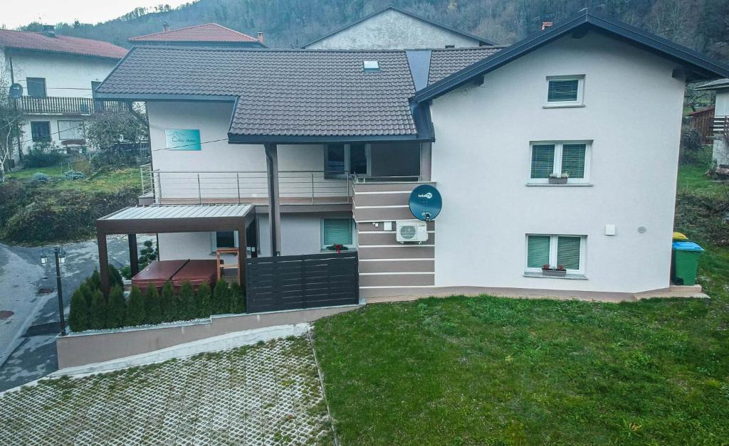 a white house with a porch and a balcony at Hiša Bohinc z wellnessom in Tolmin