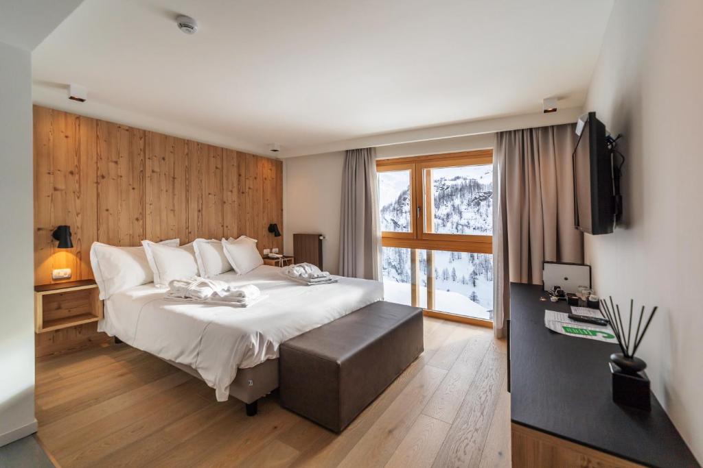 a bedroom with a large bed and a television at White Angel Hotel in Breuil-Cervinia
