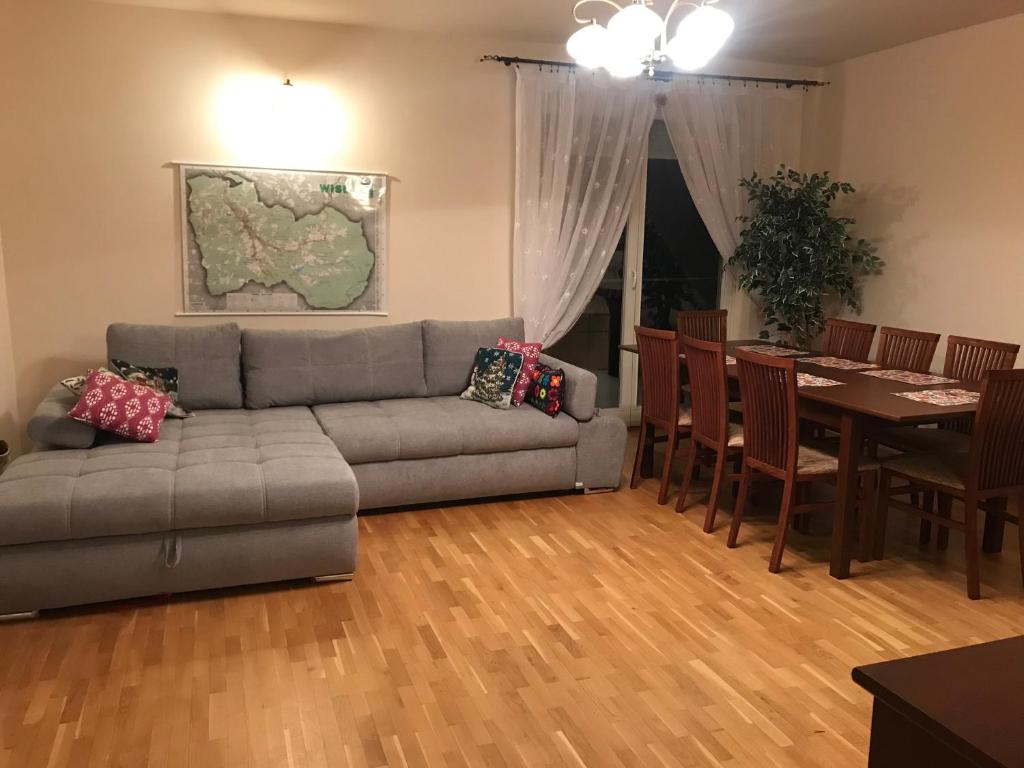 uma sala de estar com um sofá e uma mesa em Apartament Jawornik em Wisla