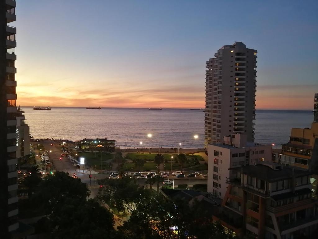 a view of the ocean from a city at sunset at Rent apartment Viña del Mar in Viña del Mar