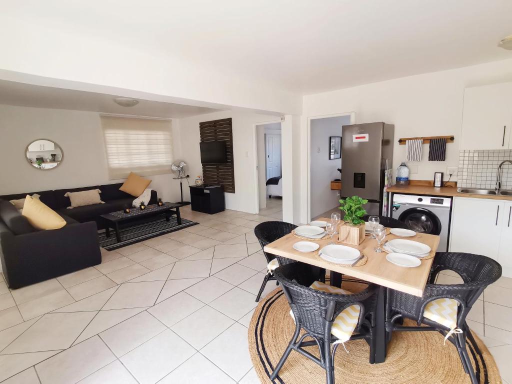 a kitchen and living room with a table and chairs at Beachfront apartment in a secure complex in Port Alfred
