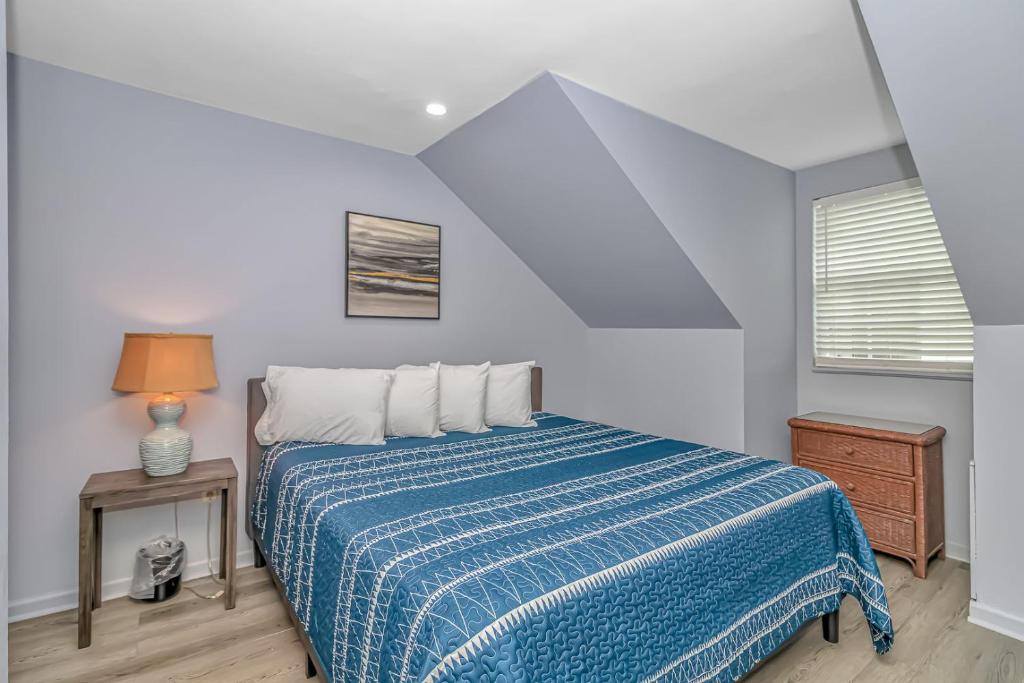 a bedroom with a bed with a blue and white blanket at 125 Atlantic Avenue Unit K - Pet Friendly! Walk To The Beach and Pier! 1BR - 1BA -Sleeps 2-4 guests! in Myrtle Beach